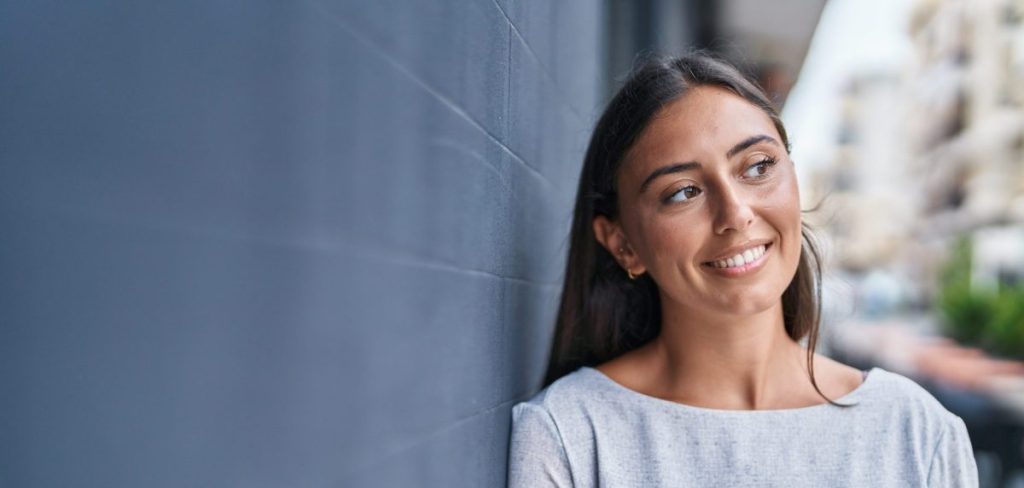 Young Woman Smiling leaning on wall